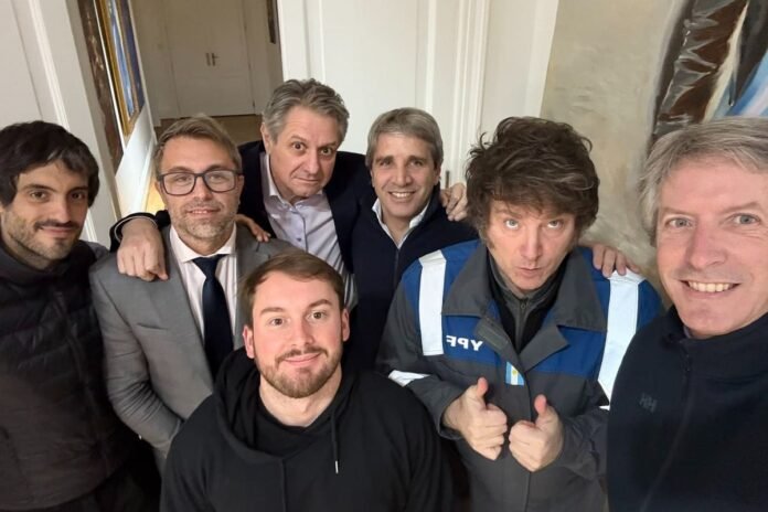 Javier Milei en Olivos con su mameluco de YPF rodeado del ministro Luis Caputo y sus colaboradores.